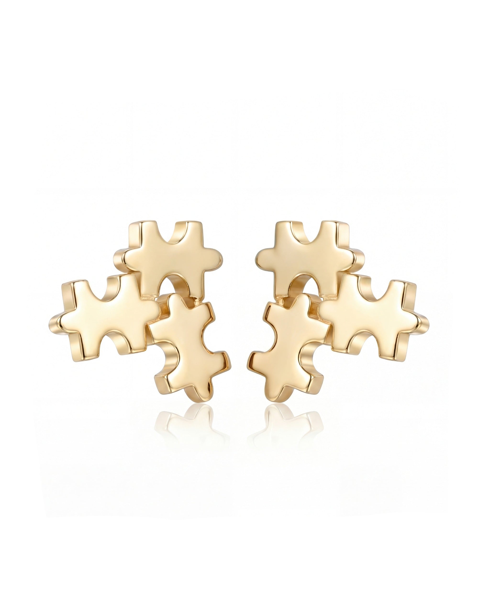 Gold puzzle piece earrings on a white background